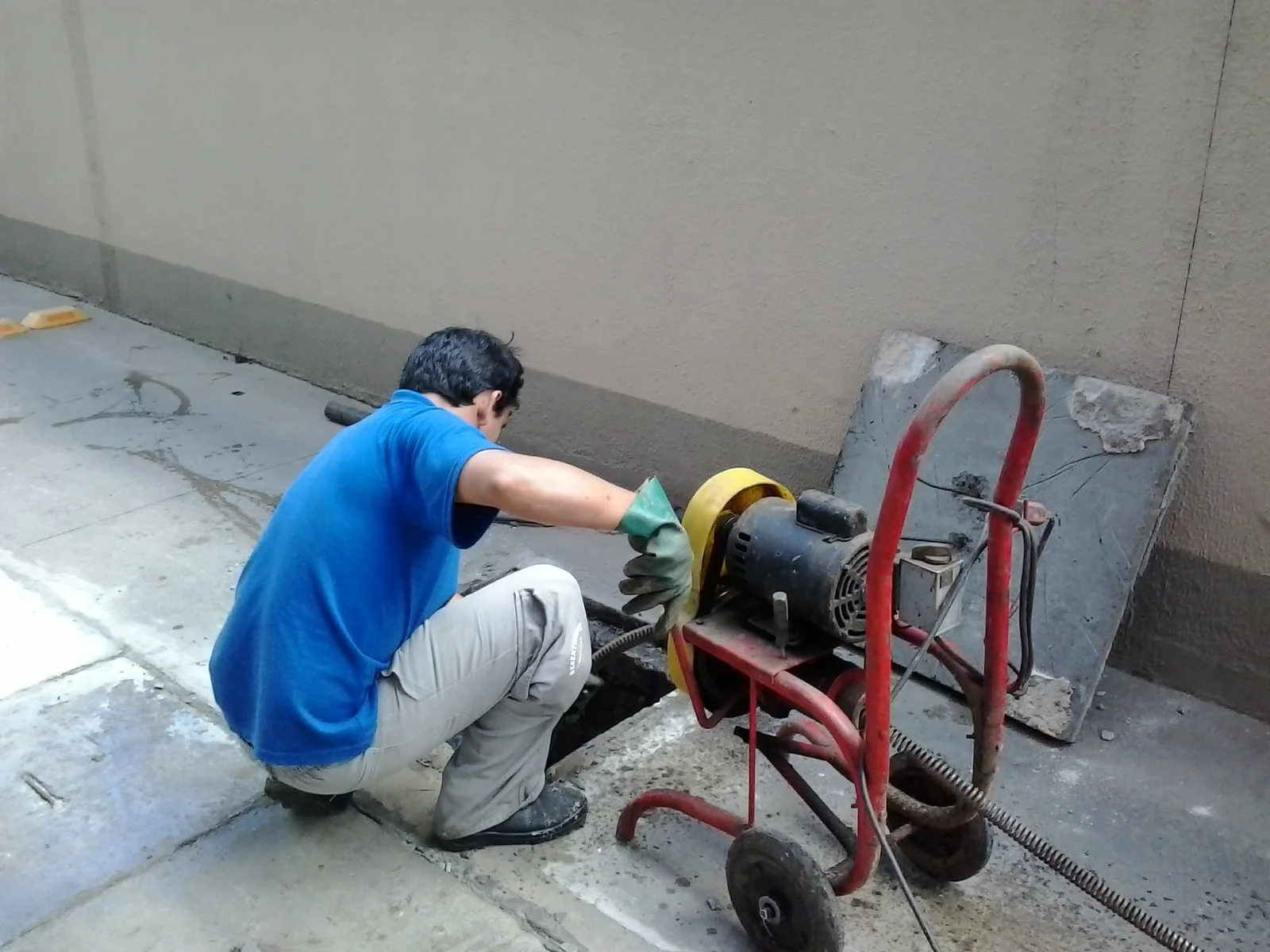 Profissional desentupindo ralo