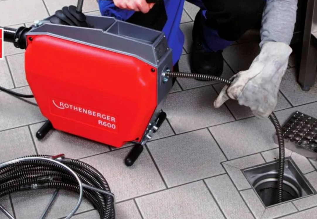 Profissional Desentupidor desentupindo ralo com máquina