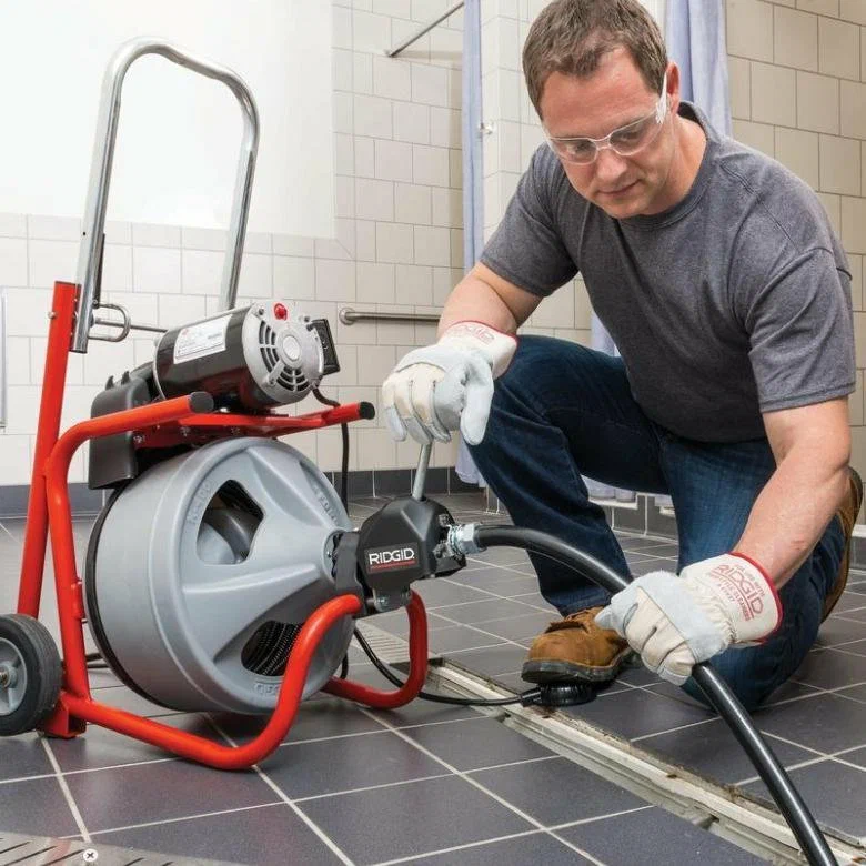 Profissional Desentupidor desentupindo ralo com máquina