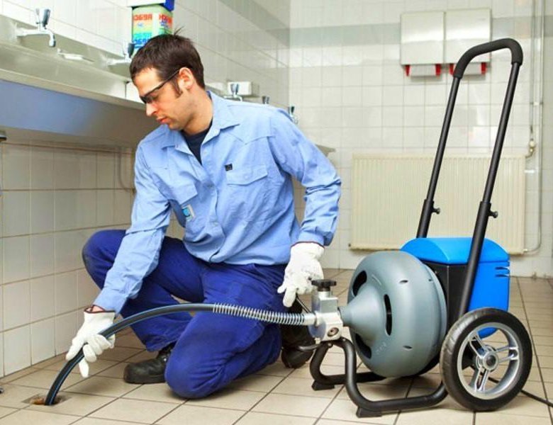 Profissional desentupidor desentupindo ralo com máquina