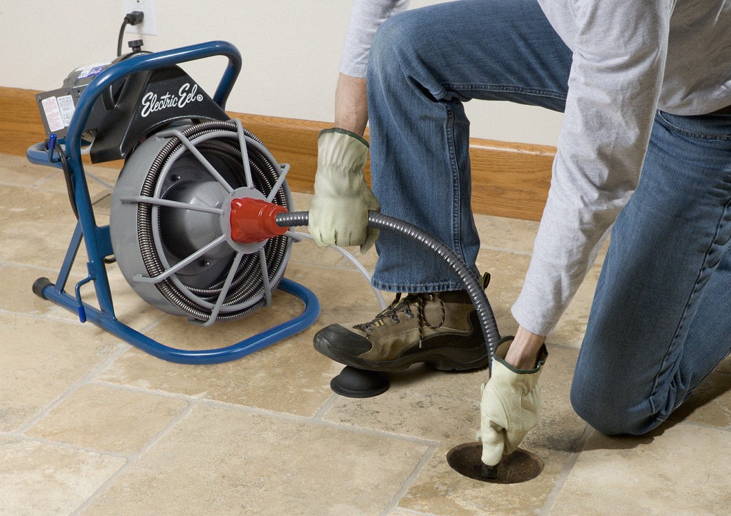 Técnico desentupidor, desentupindo ralo