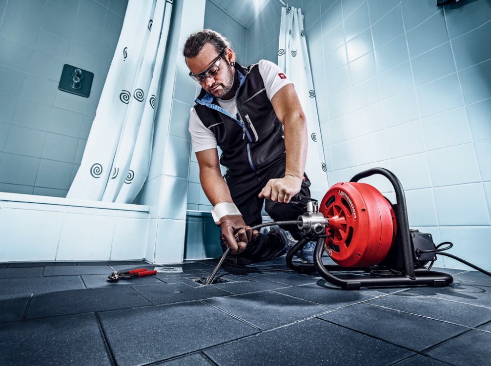 Técnico desentupidor desentupindo ralo interno