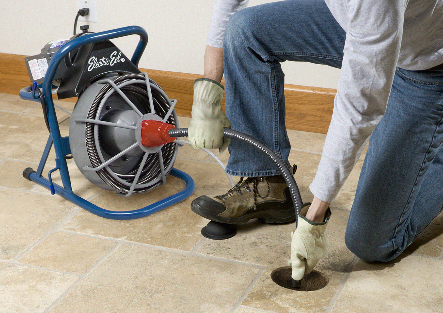 Técnico desentupidor desentupindo ralo externo com máquina