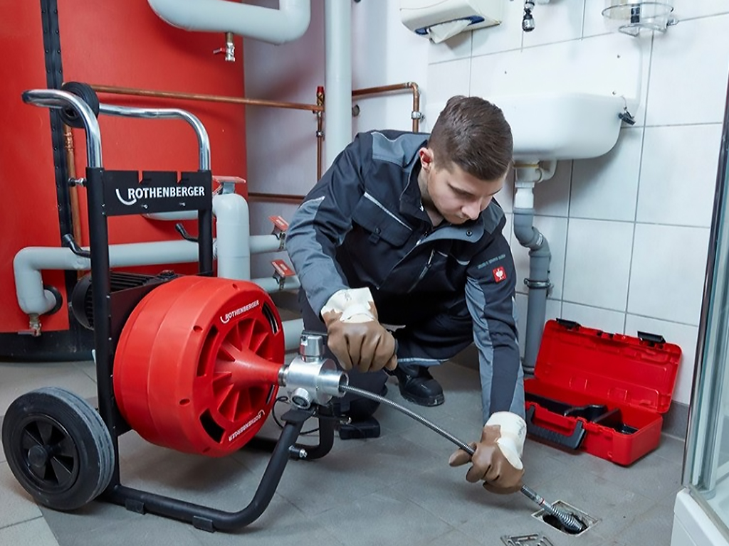 Técnico desentupidor desentupindo ralo interno na cozinha