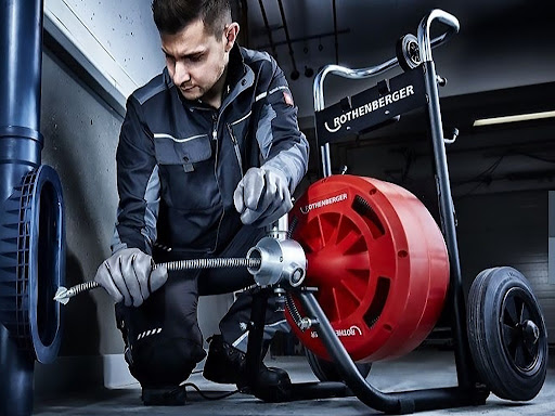Técnico desentupidor desentupindo ralo externo com máquina
