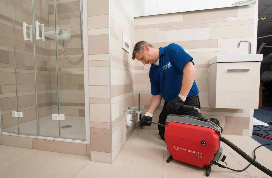 Técnico desentupidor, desentupindo ralo de banheiro